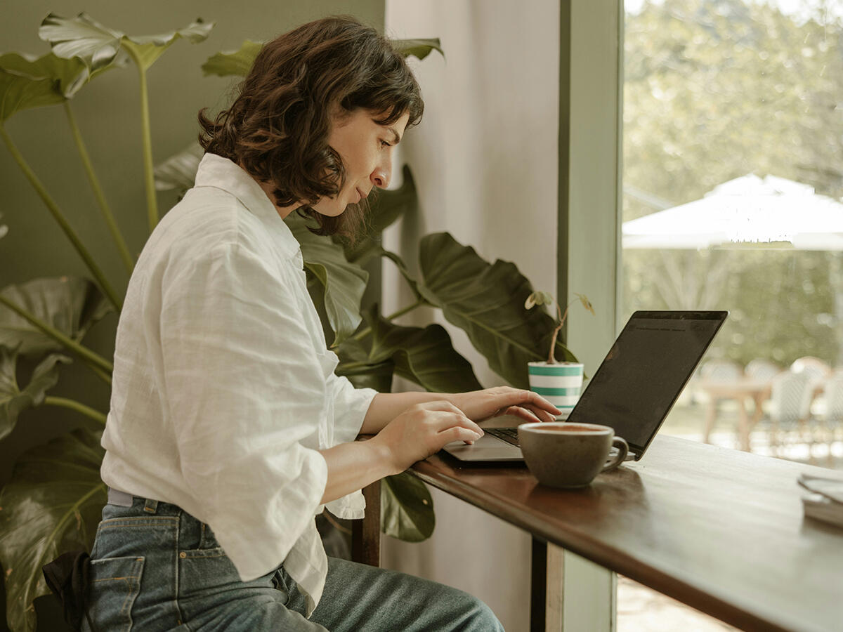 Nurse-AI-Trainer-Remote-Freedom A relaxed nurse working from a peaceful home office as a clinical AI trainer, symbolizing the exit from bedside nursing to a remote career.
